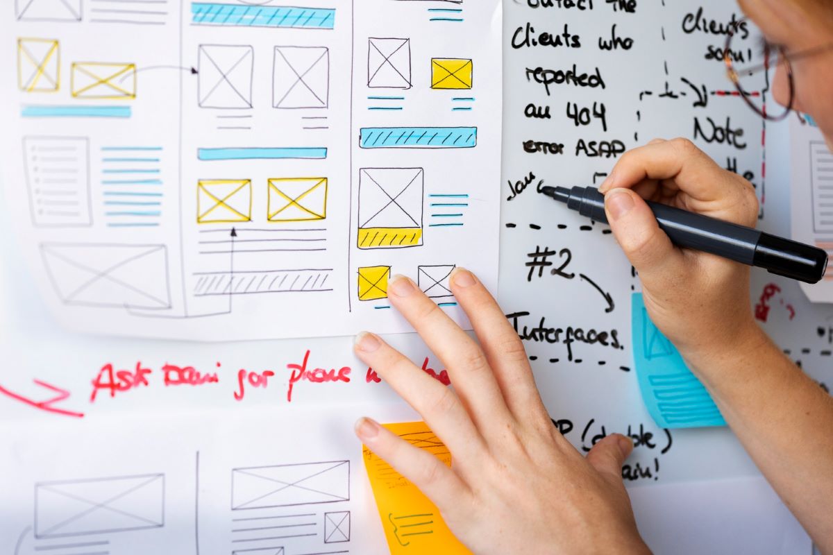 Female Web Designer With Papers And Notes